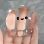 Clear Jellyfish Taba Squishy Toy being squeezed by hand