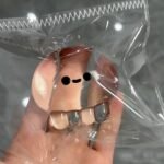 Clear Jellyfish Taba Squishy Toy being squeezed by hand